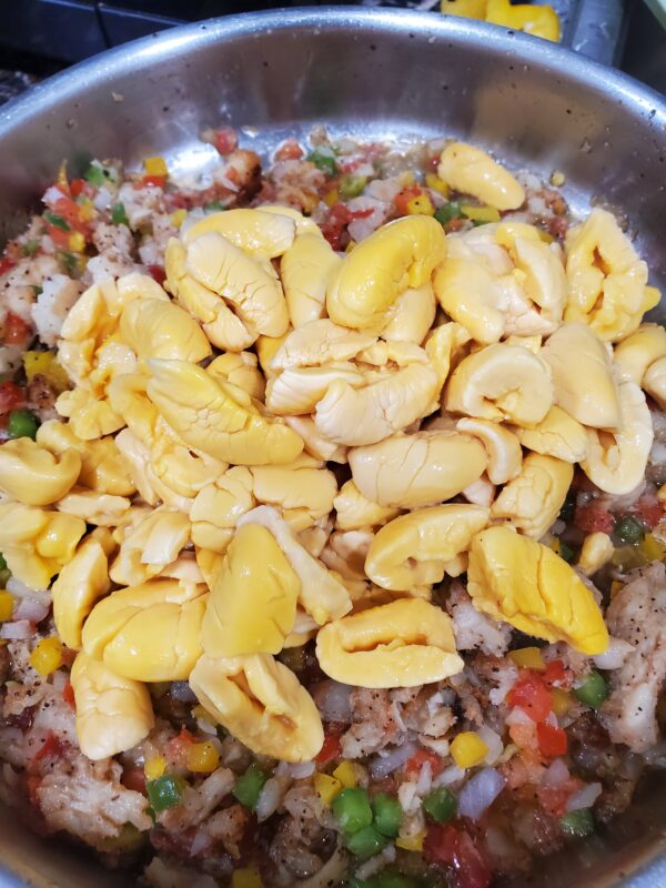 A pan filled with rice and corn on top of it.